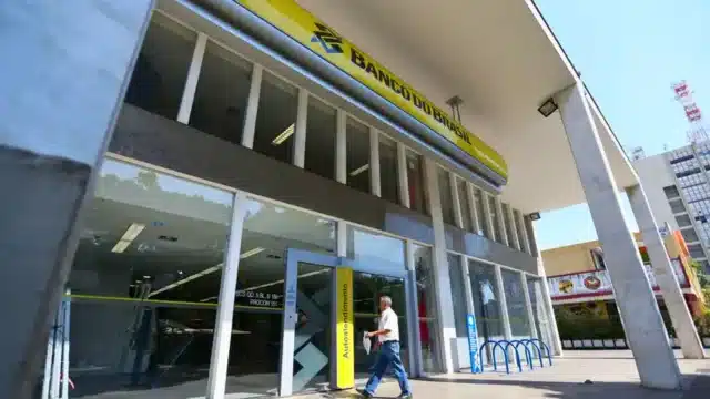 Fachada de uma agência do Banco do Brasil com o logotipo em destaque, ilustrando os desafios de recuperação da instituição frente à crise na carteira agro em 2025 e 2026.