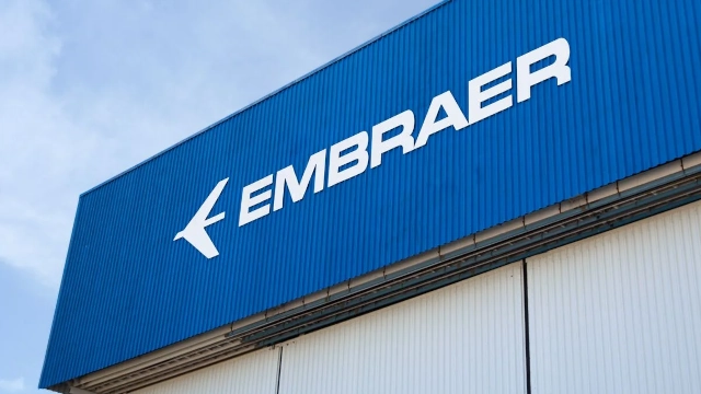 Foto mostra fachada de fábrica da Embraer