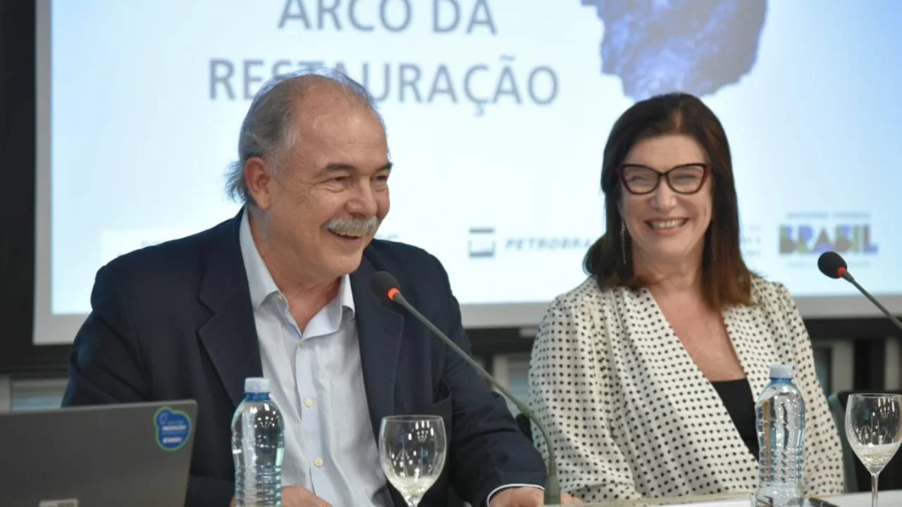 Aloizio Mercadante e Magda Chambriard em bancada de coletiva oficial sobre investimentos de Petrobras e BNDES.